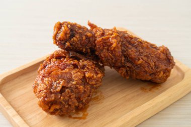 Tahta tabakta baharatlı Kore soslu kızarmış tavuk.