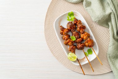 Izgara tavuk şişi. Tabakta baharat ve şifalı otlar var.