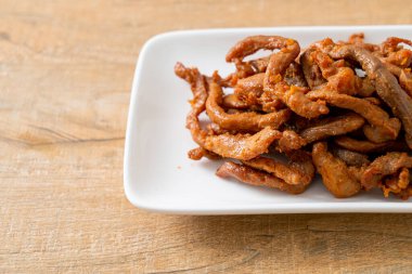 Beyaz tabakta kurutulmuş domuz eti, Asya yemeği tarzı.