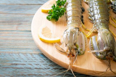 Tahtada limon olan taze peygamber devesi karidesi.