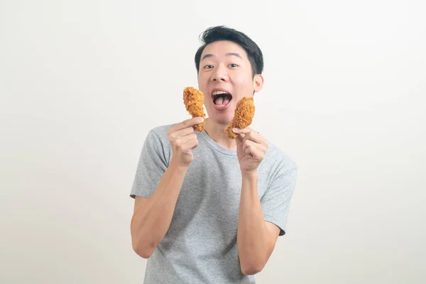 stock image portrait young Asian man with fried chicken on hand