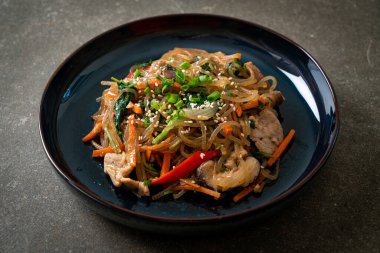 Japchae ya da karışık Kore vermicelli erişte sebzeli ve üzerine beyaz susamlı domuz eti - Kore geleneksel yemek tarzı