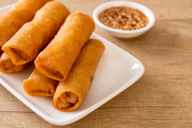 Kızarmış yumurta rulosu ve beyaz tabakta sos.