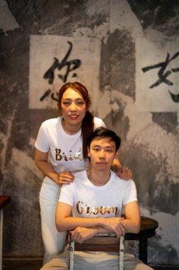 Gelin ve damat tişörtlü mutlu Asyalı çift evlenmeye ve evlenmeye hazır.