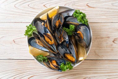 Limonlu bir kasede otlu taze midyeler.