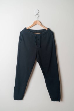 eşofman altı ya da duvarda ahşap askıyla asılı koşucu pantolonu