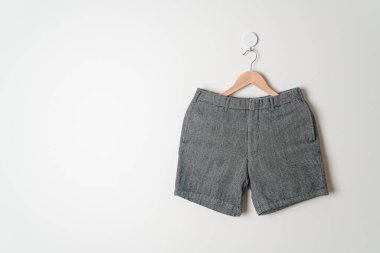 Kısa pantolon duvarda ahşap bir askıyla asılı.