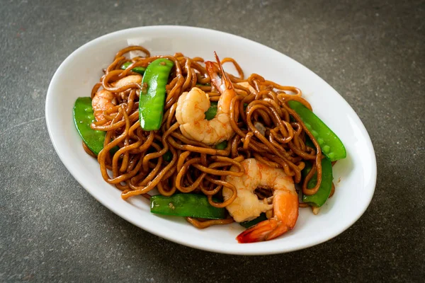 Kızarmış yakisoba eriştesi, yeşil bezelye ve karides, Asya usulü.
