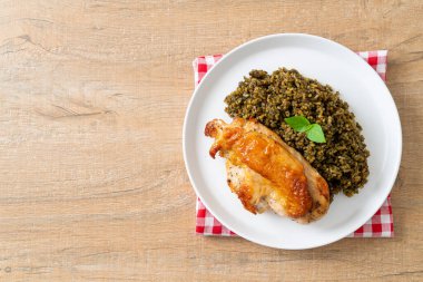 Kızarmış pesto pilavı ve beyaz tabakta kızarmış tavuk.
