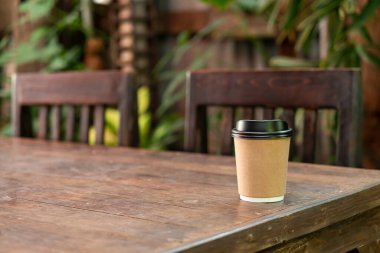 Tahta masada fotokopi alanı olan sıcak kahve fincanı.