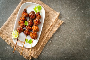 Izgara tavuk şişi. Tabakta baharat ve şifalı otlar var.