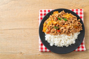 Pirinçli yumurta ve fesleğenli kızarmış domuz eti. Asya usulü.