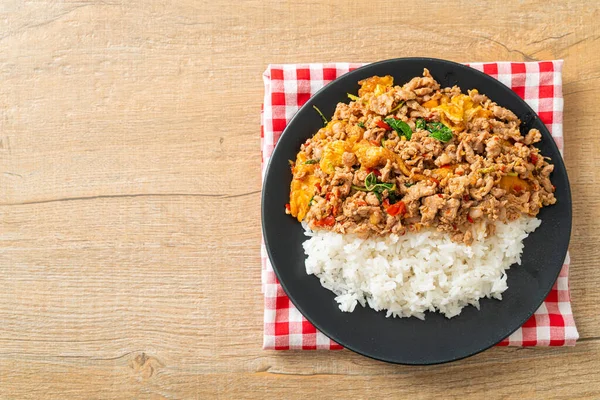 Pirinçli yumurta ve fesleğenli kızarmış domuz eti. Asya usulü.