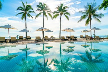 Otelde ve tatil beldesinde yüzme havuzunda güzel şemsiye ve sandalye - tatil kavramı