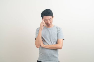 Beyaz arka planda düşünen genç Asyalı adam portresi