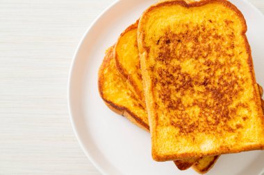 Kahvaltı için beyaz tabakta yumurtalı ekmek.