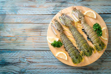 Tahtada limon olan taze peygamber devesi karidesi.