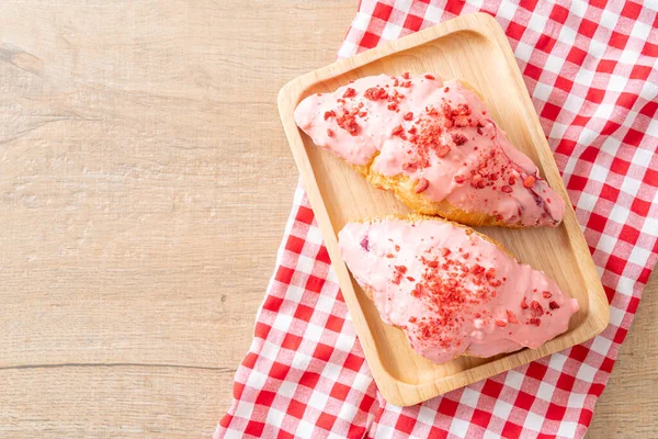 Tahta tabakta çilekli çikolata soslu kruvasan.