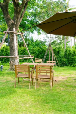 Boş ahşap masa ve bahçede sandalye.