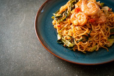 Karıştırılmış hazır erişteli sukiyaki, karidesli, Asya usulü.