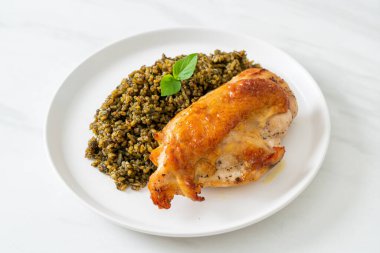 Kızarmış pesto pilavı ve beyaz tabakta kızarmış tavuk.