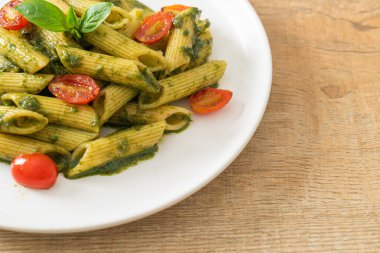 Pesto soslu ve domatesli makarna. Vejetaryen ve vejetaryen yemek tarzı.