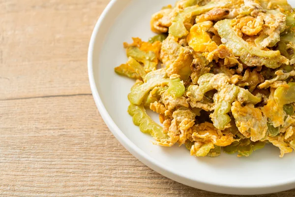 Kızarmış acı kabağı tabakta yumurta ile karıştır