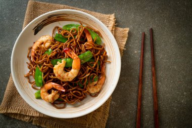 Kızarmış yakisoba eriştesi, yeşil bezelye ve karides, Asya usulü.