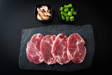 Taze domuz boyunlu ya da yakalı domuz eti ve terbiye edilecek malzemeler.