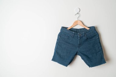 Duvarında ahşap askılı kısa pantolon.