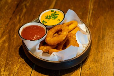 Ketçaplı soğan halkası ve tabakta sos.