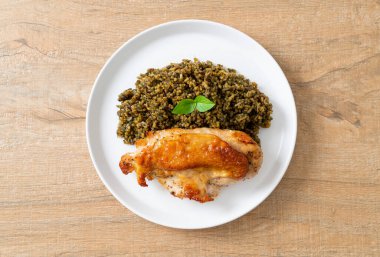 Kızarmış pesto pilavı ve beyaz tabakta kızarmış tavuk.