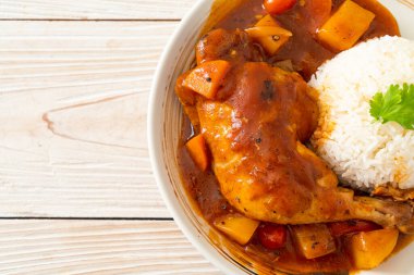 Domatesli ev yapımı tavuk güveci, soğan, havuç ve patates tabakta pilav.