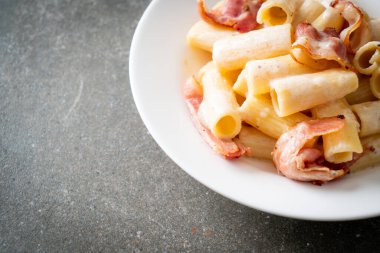 Beyaz soslu ve pastırmalı ev yapımı spagetti rigatoni makarna. İtalyan usulü.