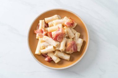 Beyaz soslu ve pastırmalı ev yapımı spagetti rigatoni makarna. İtalyan usulü.