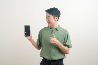 Beyaz arka planda akıllı telefon ve cep telefonu kullanan ya da konuşan genç Asyalı adam