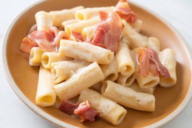 Beyaz soslu ve pastırmalı ev yapımı spagetti rigatoni makarna. İtalyan usulü.