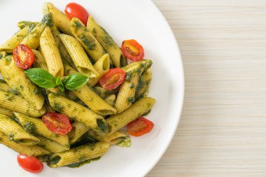 Pesto soslu ve domatesli makarna. Vejetaryen ve vejetaryen yemek tarzı.