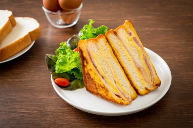 Beyaz tabakta salatalı ev yapımı jambonlu peynir.