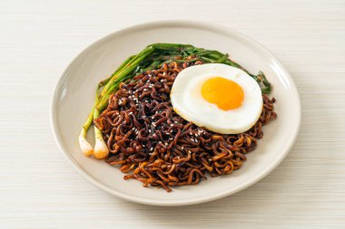 Ev yapımı kurutulmuş Kore baharatlı baharatlı siyah sos kızarmış yumurta ve kimchi ile hazır erişte.