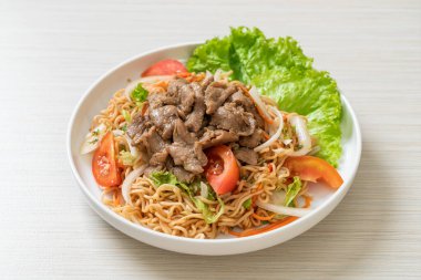 Beyaz tabakta domuz etli hazır şehriye salatası. Asya usulü.