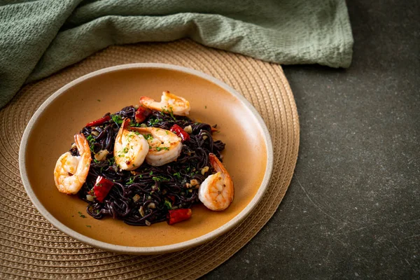 Sarımsaklı ve karidesli kızarmış siyah spagetti.