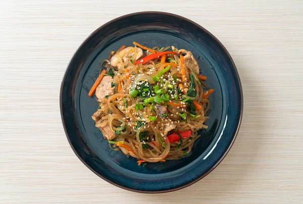 白ゴマの上に野菜と豚肉をのせた日本風または炒め物の韓国の春雨麺 韓国の伝統料理 — ストック写真