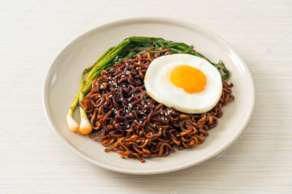 Homemade dried Korean spicy black sauce instant noodles with fried egg and kimchi