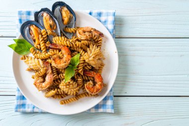 Deniz ürünleri ve fesleğen soslu kızarmış spiral makarna. Füzyon yemek tarzı.