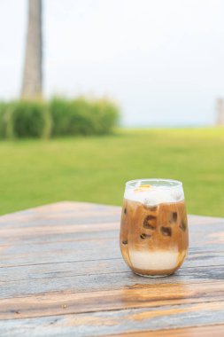 Ahşap masada buzlu kahve bardağı.