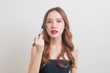 Beyaz arka planda makyaj fırçası olan güzel bir Asyalı kadın portresi