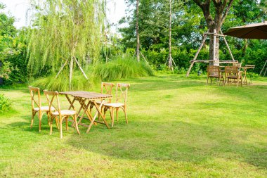 Boş ahşap masa ve bahçede sandalye.