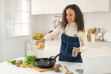 Latin kadın blogda paylaşmak için mutfakta video ve yemek çekiyor.