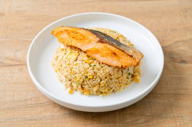 Kızarmış pilav ve ızgara somon filetosu. Beyaz tabakta biftek.